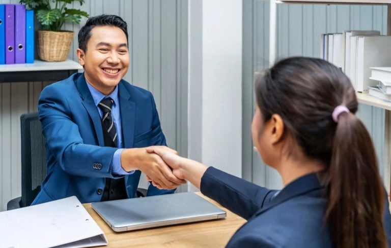 EB-3 visa interview questions: applicant shaking hands with the interviewing officer